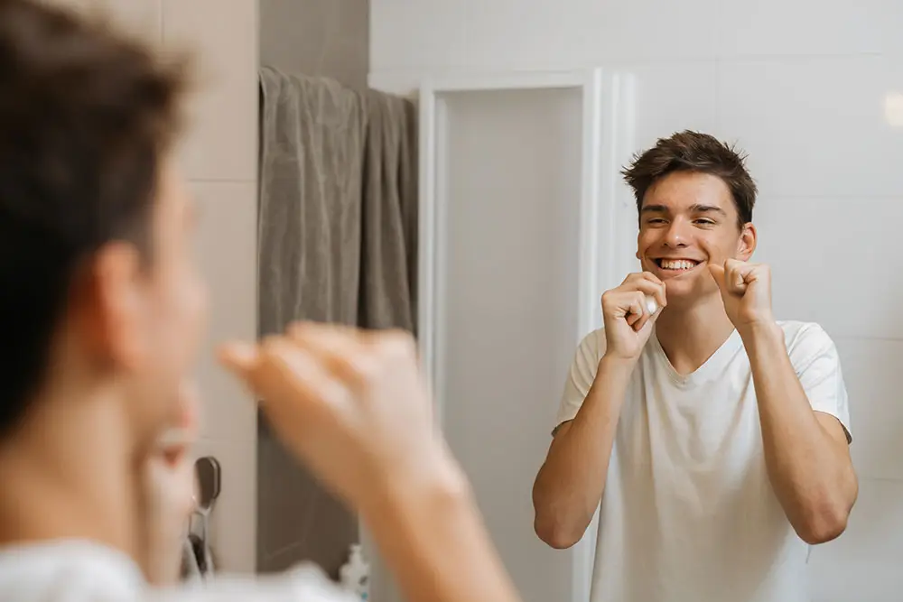 Man flossing in the mirror
